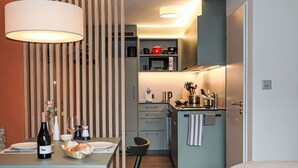 A compact kitchen with a dining area, a microwave, and a sink. - Beautiful apartment for 2 guests with WIFI, TV and balcony (Zermatt)