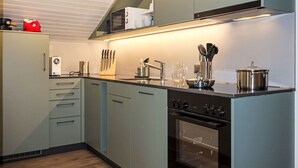Eine moderne Küche mit Einbauofen, Mikrowelle und Spüle aus Edelstahl.