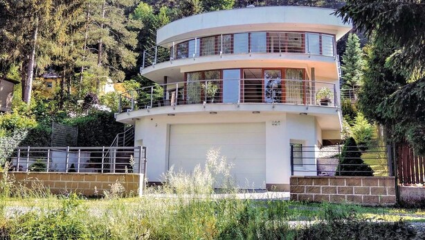 A multi-level, modern building with balconies, surrounded by dense forest. - Nice apartment for 4 guests with WIFI, TV, terrace and panoramic view (Vlašim)