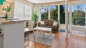 A modern living room with a sofa, a dining table, and a kitchen area. - Nice apartment for 4 guests with WIFI, TV, terrace and panoramic view (Vlašim)