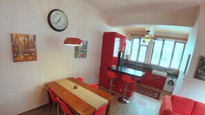 A compact living space with a dining area, kitchen, and a red sofa. - 2 Bedroom Apartment beautifully decorated in the centre of Sai Kung Town. (New Territories)