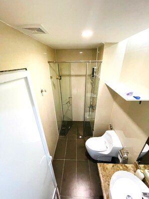 A bathroom with a glass-enclosed shower, a toilet, and a sink. - Diamond Suite Golden King  (Ho Chi Minh City)