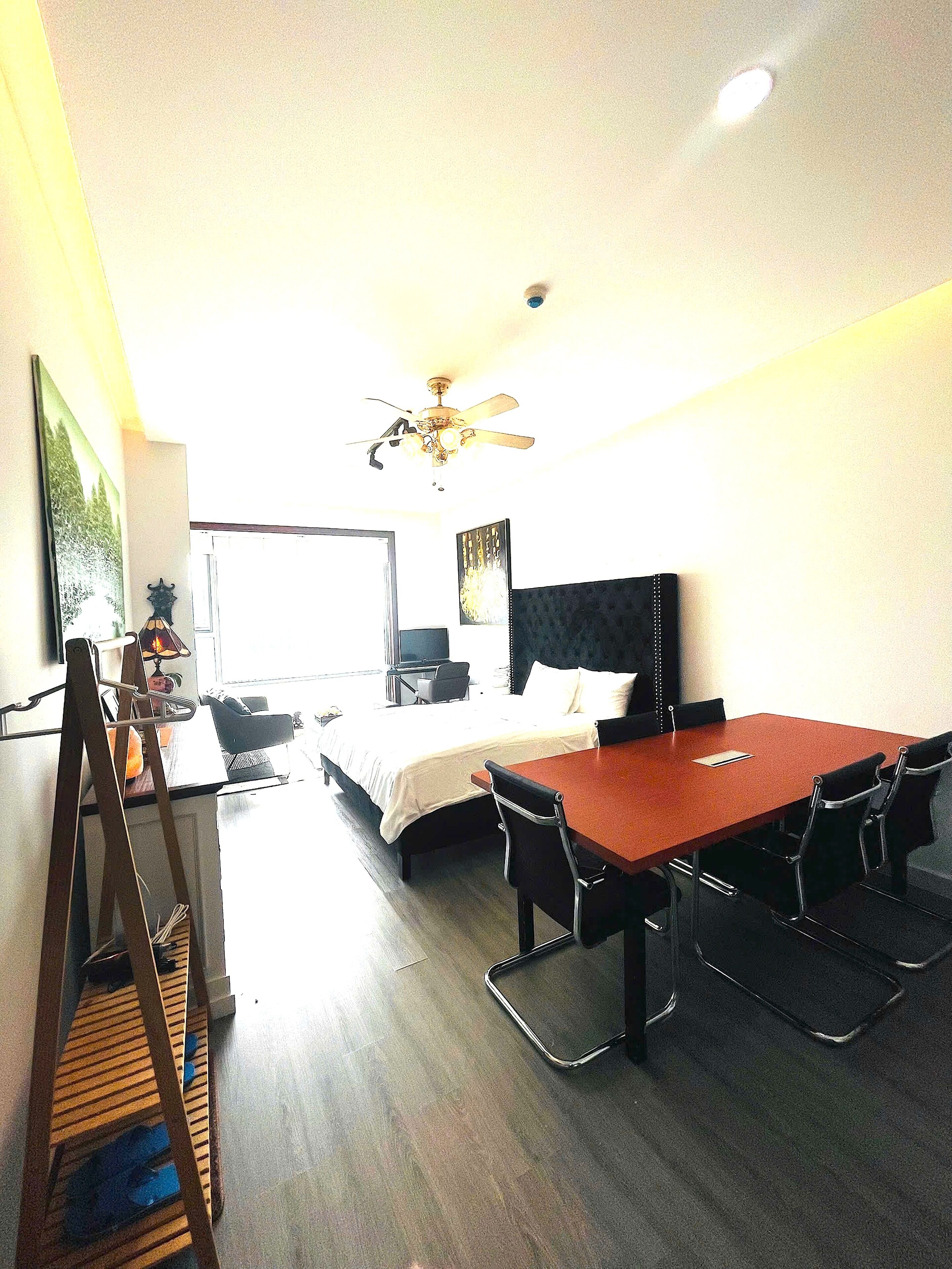 A hotel room with a bed, a desk, and a dining table.