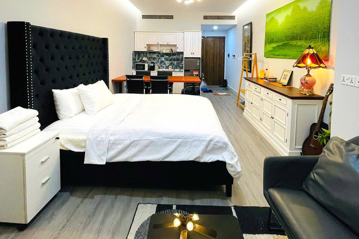 Ein modernes Hotelzimmer mit einem großen Bett, einem Schreibtisch, einem Essbereich und einem Deckenventilator.