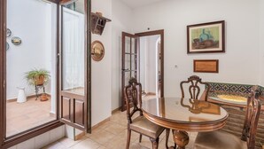 Un coin repas avec une table ronde et des chaises, un grand miroir et un tableau accroché au mur.