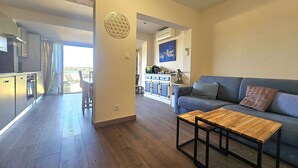 Una sala moderna con sofá, mesa de centro y vistas a un balcón.