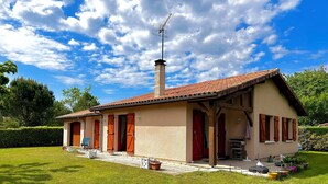 Une maison à deux étages, avec un toit en tuiles, une cheminée et une antenne parabolique.