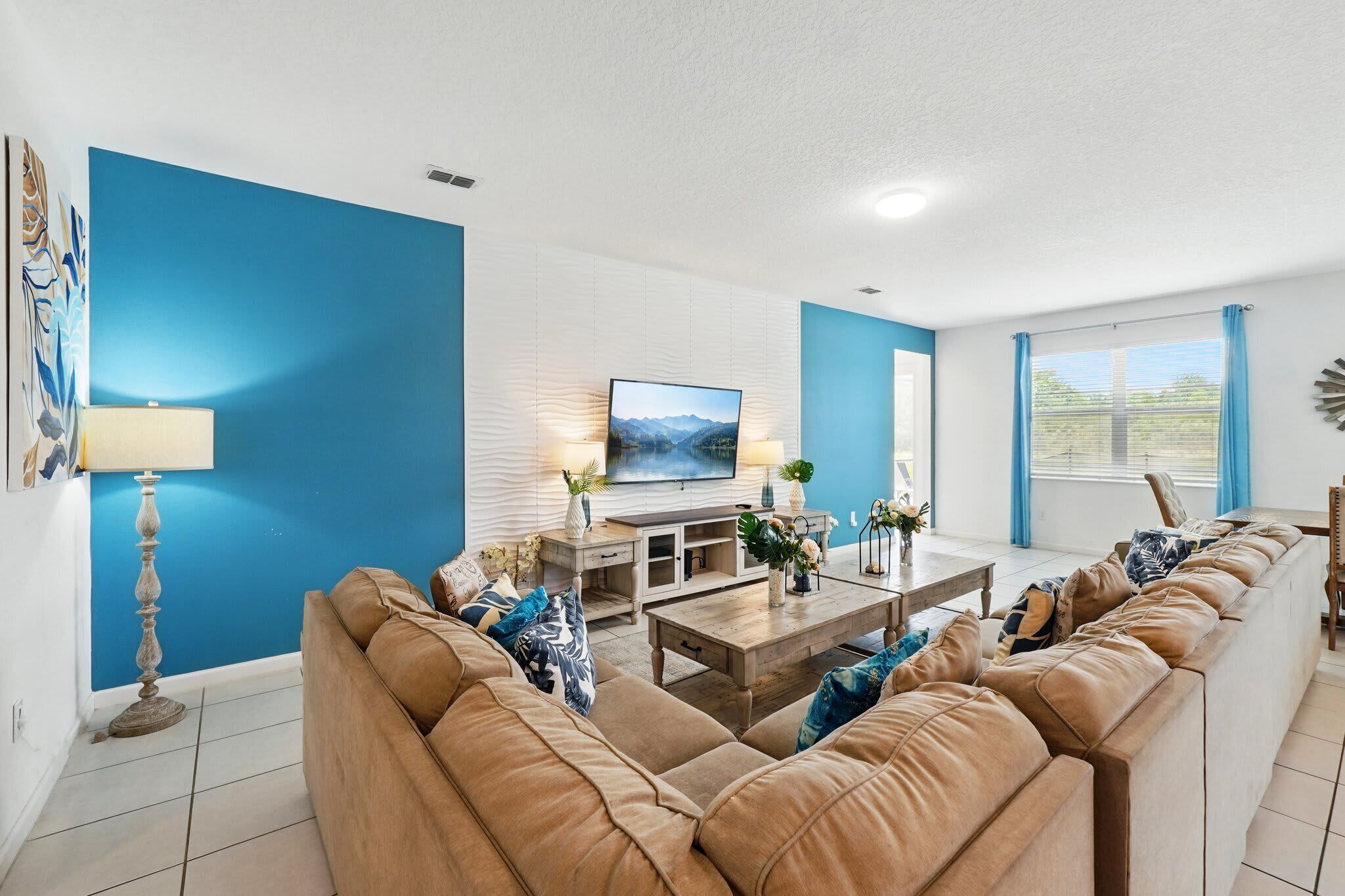 A modern living room with a large sofa, a TV, and a coffee table.