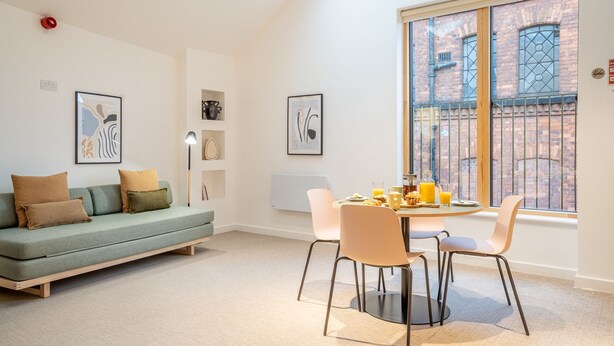 A modern living room with a sofa, chairs, a dining table, and artwork on the walls. - King Street Studios - King Henry IV (York)