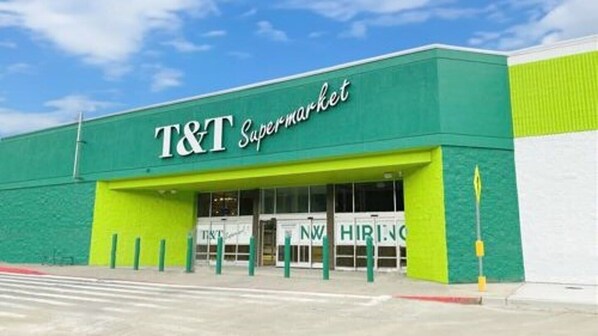 A T&T Supermarket with a green facade and a clear blue sky in the background.