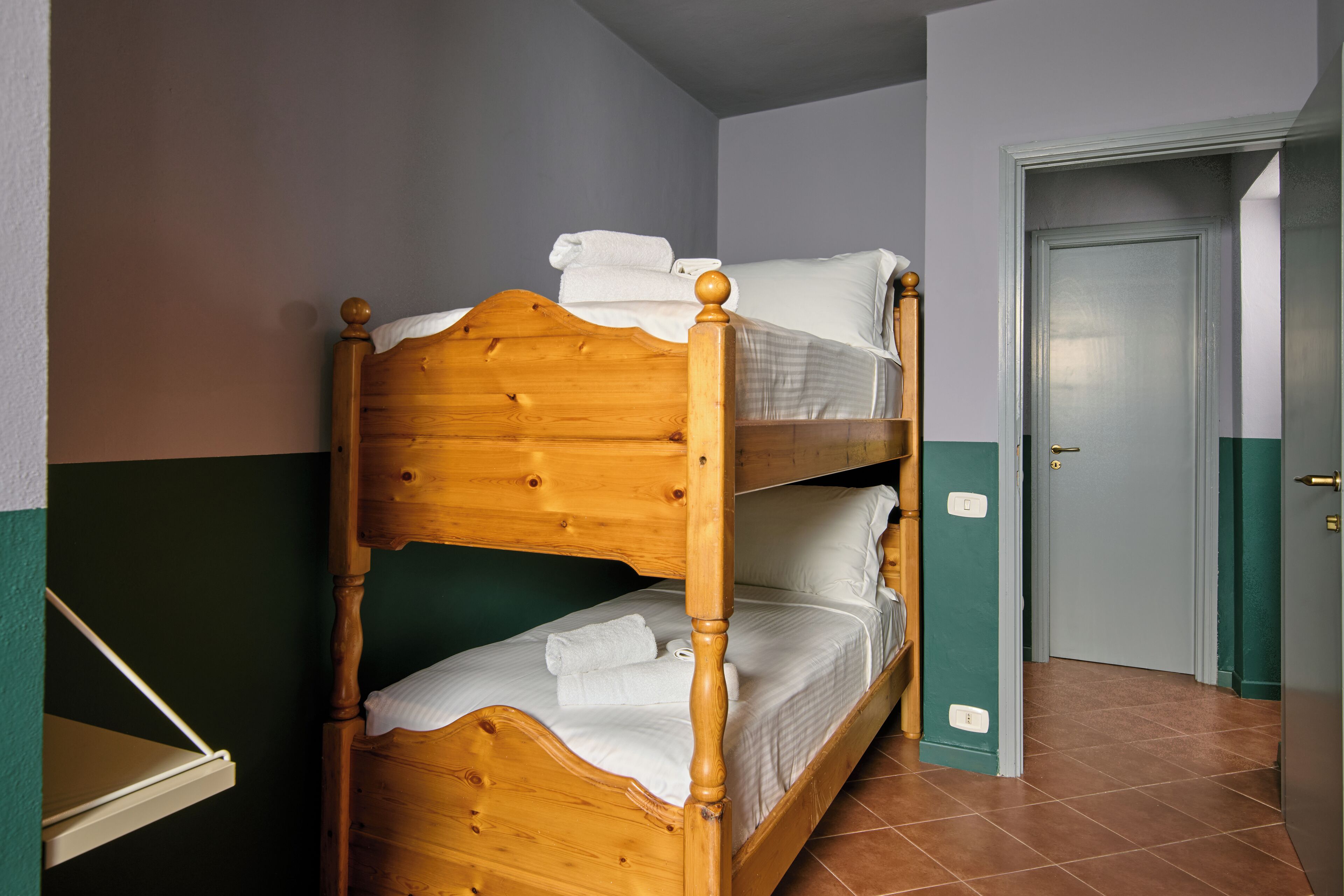 Un lit superposé avec une literie blanche et une tête de lit en bois.