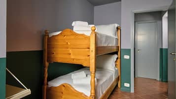 Un lit superposé avec une literie blanche et une tête de lit en bois.