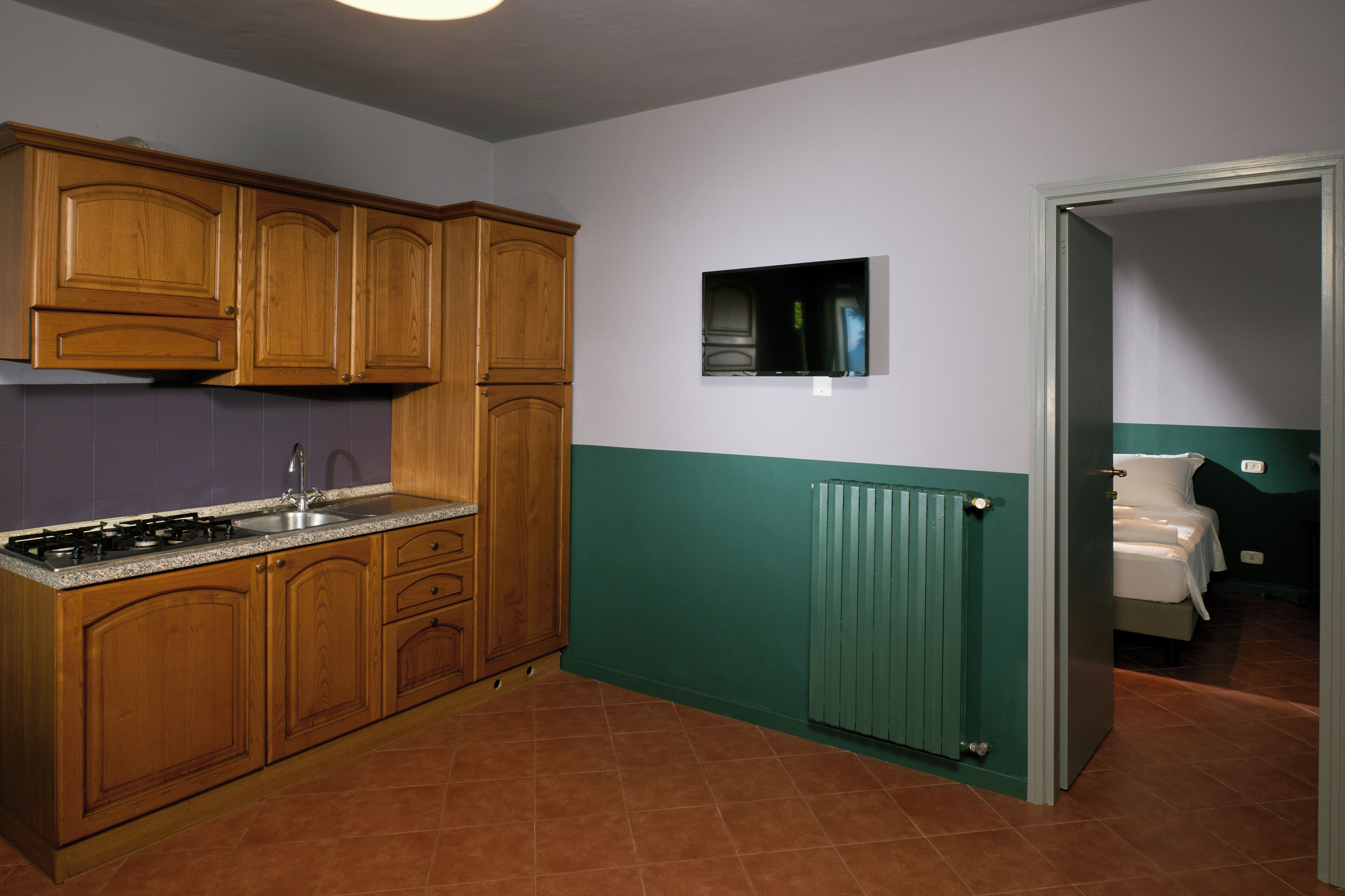 A kitchen with wooden cabinets, a stove, and a built-in microwave.
