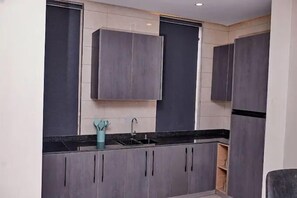 Departamento familiar, balcón, vista a la ciudad | Cocina privada | Refrigerador, microondas, horno y parrilla de estufa 