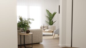 Een moderne woonkamer met een bank, een salontafel en een grote plant.