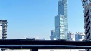 Un gratte-ciel moderne et imposant, doté d’une façade en verre, entouré d’autres immeubles.