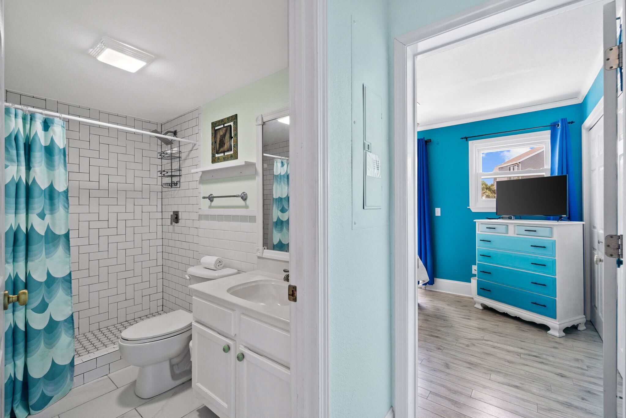 A bathroom with a shower, toilet, sink, and vanity.
