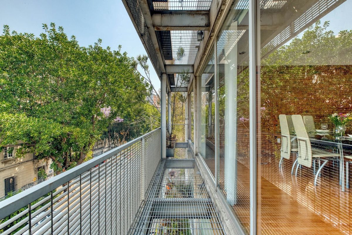 Leafy top-floor balcony walkway with seating, sip your coffee among the treetops of Roma Norte