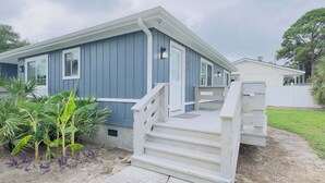 A single-story house with a blue exterior, white trim, and a front porch with steps leading to a door. - Bright & airy 2BR, 2BA beach retreat A (North Myrtle Beach)