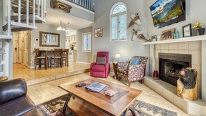 Un salón amplio con chimenea, zona de comedor y cocina.