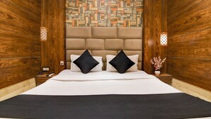 A hotel room with a large bed, wooden walls, a patterned wall, and two bedside lamps. - BRILL MARINA (Kolkata)