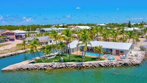A coastal property with a swimming pool, palm trees, and a view of the ocean. - *NEW!*Paradise Point~VIEWS!~Open Water~Dock~Pool! (Marathon)