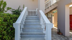 Eine Treppe mit weißen Geländern, die zu einer Empore führt.
