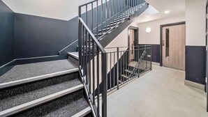 A staircase with black railings leading to a landing.