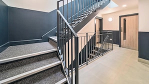 A modern staircase with black railings leading to a landing.