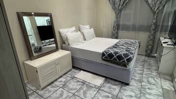 Tabla de planchar con plancha, internet y ropa de cama
