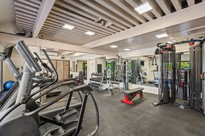 Una palestra con tapis roulant, macchinari per pesi e pesi liberi.