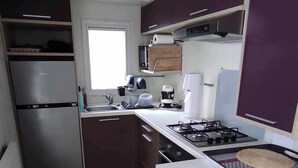 Una cocina compacta equipada con refrigerador, estufa, microondas y lavaplatos.