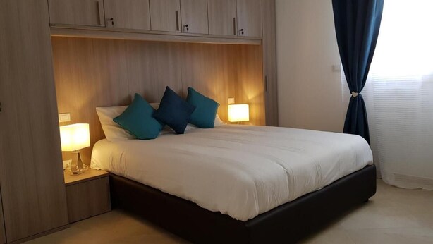 A bedroom with a bed, two bedside lamps, a nightstand, and a wardrobe. - L&G's Roof Terrace, near the Tower of Pisa. (Pisa)