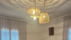 Un salon avec deux canapés, une table basse et un luminaire suspendu au plafond.