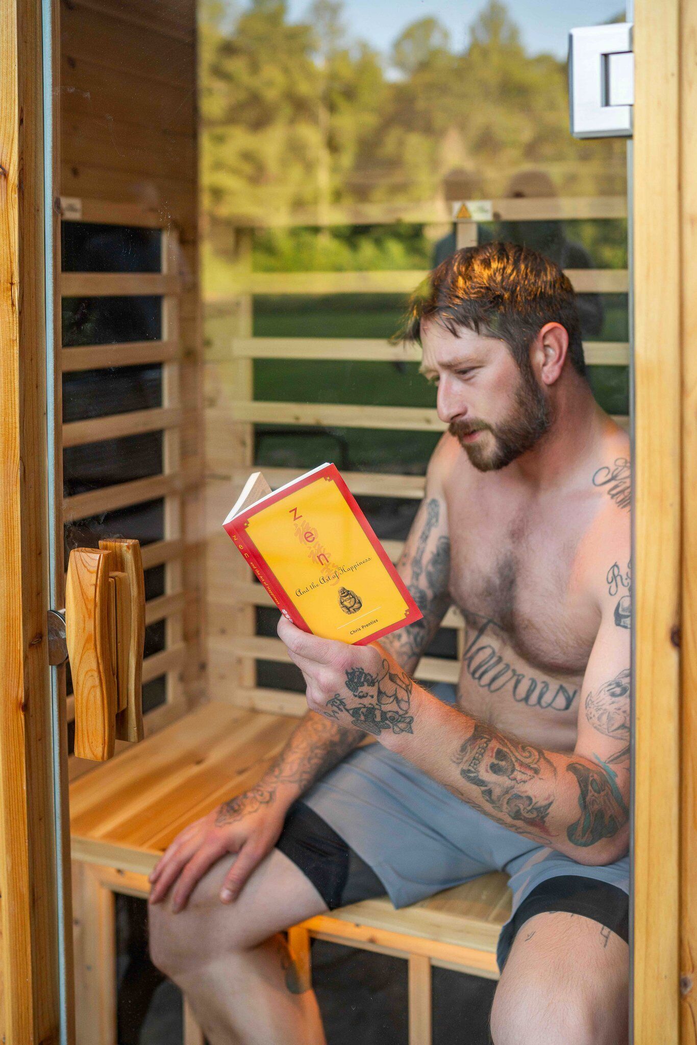 Uma pessoa sentada em uma sauna lendo um livro.