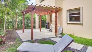 A covered patio with lounge chairs, a pergola, and a barbecue area. - Yard w/ Lake View: Remote Working Hub in Homestead (Homestead)