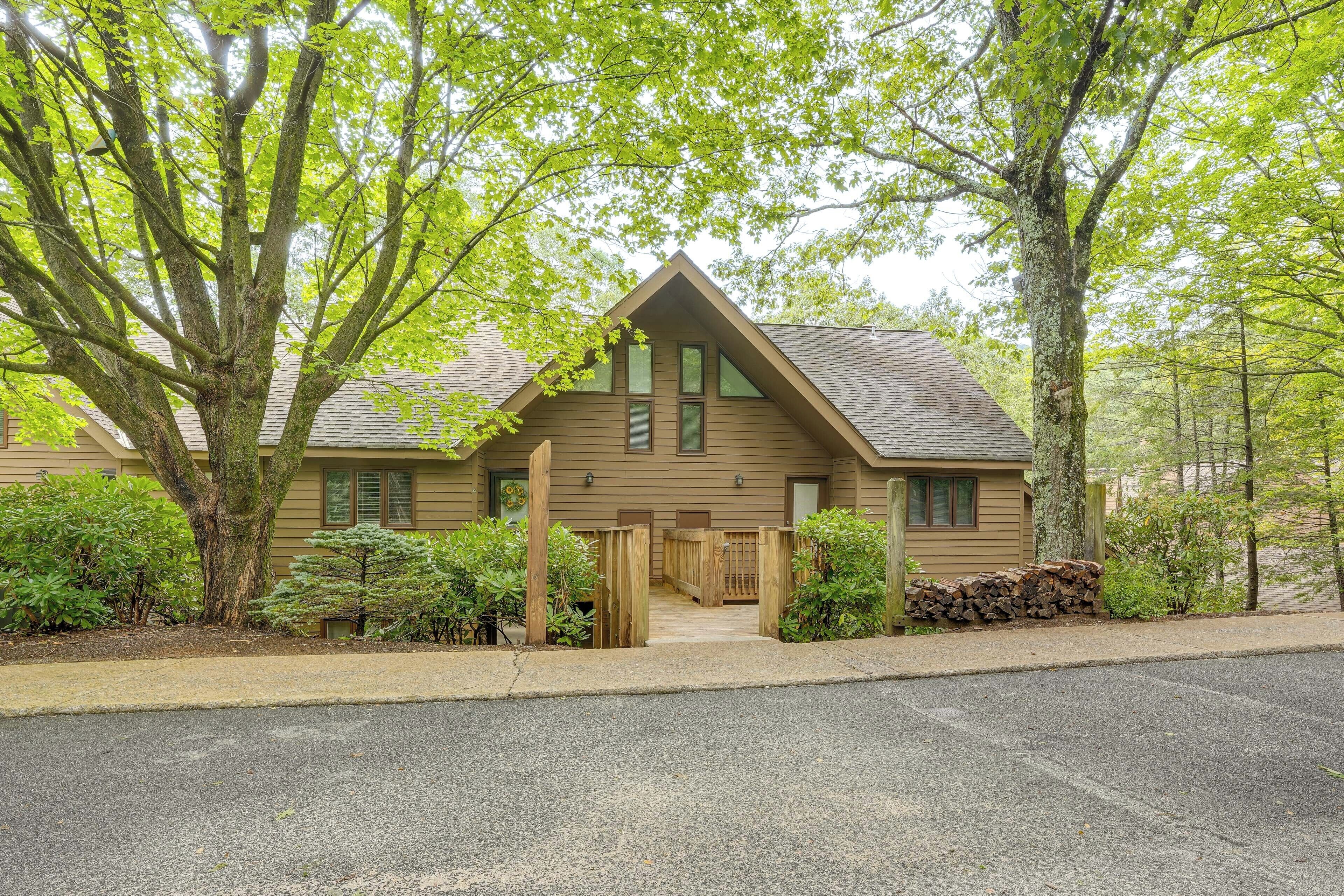 A lodge with a wooden exterior, a front porch, and a stone wall.