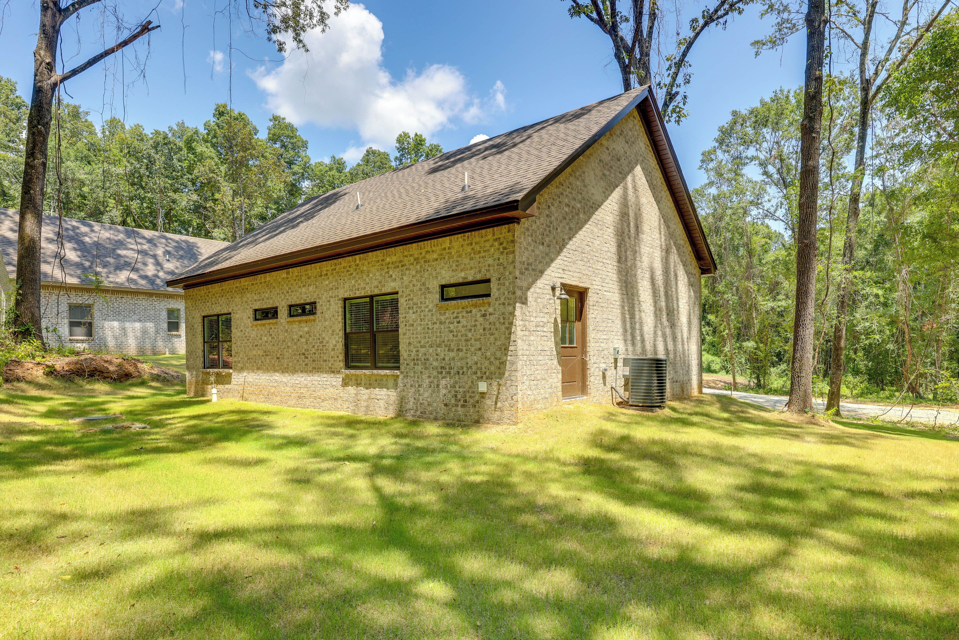A single-story stone building with a sloped roof, a front door, and a small porch area.