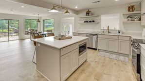 Una cocina moderna con una isla central, electrodomésticos integrados y vistas al exterior.