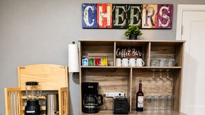 Angolo cottura con angolo caffè, frullatore, macchina del caffè e una bottiglia di vino.