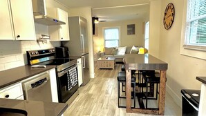 Una cocina moderna con una isla central, electrodomésticos de acero inoxidable y una lámpara única.