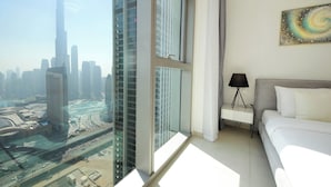 A modern hotel room with a large window offering a view of a city skyline and a body of water. - Silk Valley - Luxury 2B near Dubai Mall (Dubai)