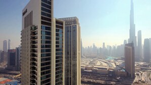 A high-rise building with a modern architectural design, featuring multiple floors and a prominent glass facade. - Silk Valley - Luxury 2B near Dubai Mall (Dubai)