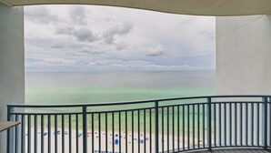 A balcony with a view of the ocean and beach.