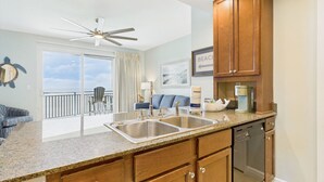 A kitchen with granite countertops, wooden cabinets, a double sink, and a dishwasher.