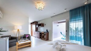 Ein modernes Hotelzimmer mit Bett, Schreibtisch, Sofa, Lampe und Blick nach draußen.
