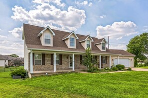 A two-story house with a front porch, a garage, and a well-maintained lawn. - Oglesby Vacation Home 6 Bedroom Home (Oglesby)