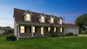 A two-story house with a front porch, brick exterior, and a garage.
