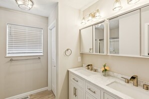 A bathroom with a large mirror, two sinks, and a towel rack. - Oglesby Vacation Home 6 Bedroom Home (Oglesby)
