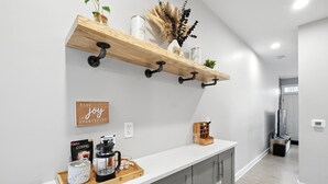 Eine Küche mit einem Holzboden, einer Kaffeemaschine und einer Ablage mit Kaffeekanne und einer Kiste.